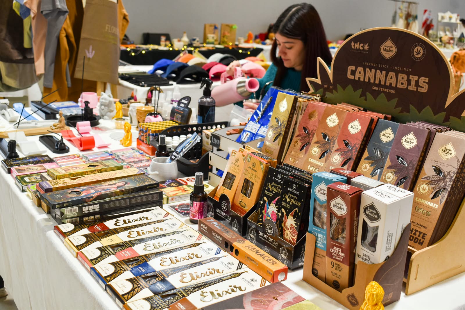 Mesa con productos y una persona trabajando al fondo